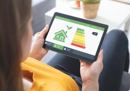 Blick über die Schulter einer Frau, die ein Tablet in der Hand hält, auf dem die verschiedenen Energieeffizienzklassen abgebildet sind.