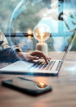 Schreibtisch, auf dem ein Laptop und ein Handy leigt 