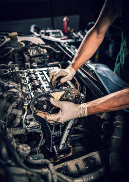 Eine Person die an einem Automotor arbeitet