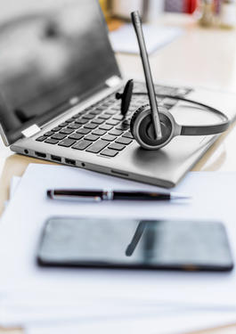 Tisch auf dem ein Laptop steht und ein Handy liegt