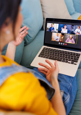Person am Laptop, in einem Online Meeting
