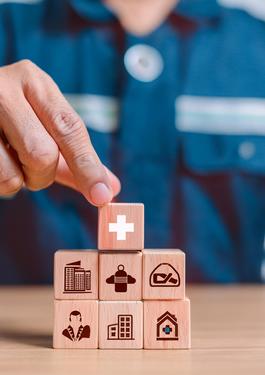 Person mit Würfeln vor sich. Die WÜrfel haben verschiedene Symbole zu HSE