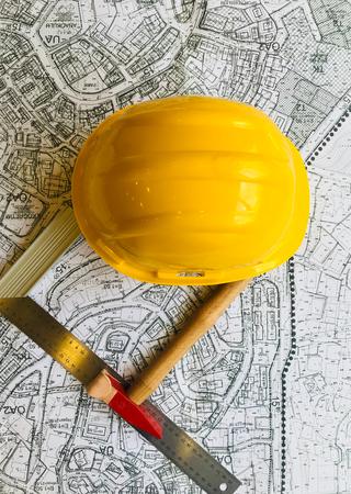 Ein Helm und Werkzeug liegend auf einem Plan