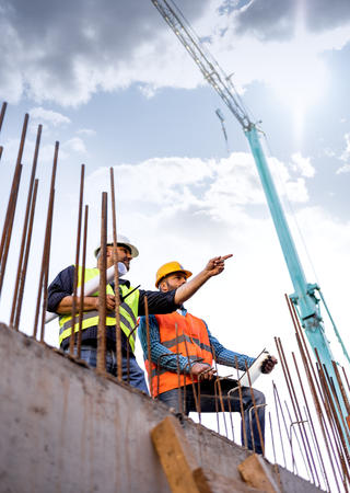 Zwei Männer in Arbeitsschutzkleidung auf einer Baustelle