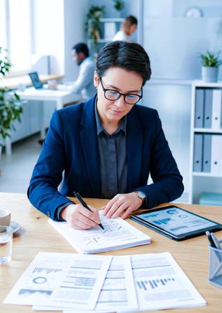anager oder Qualitätsleiter betrachtet Produktionsmuster oder Prüfberichte im Büro / Meetingraum 