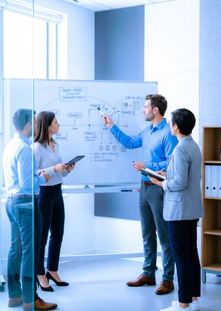 Projektteam bespricht Zertifizierungsfahrplan vor Whiteboard mit Prozessdiagramm und Meilensteinen.