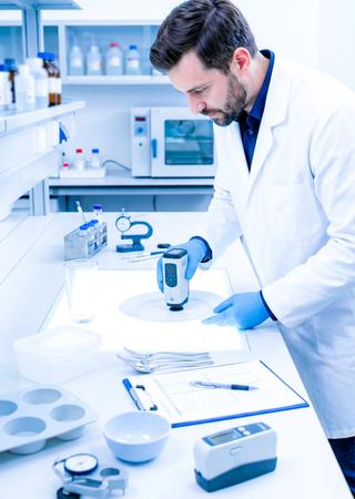 Qualitätsingenieur prüft Lebensmittelkontaktprodukte im Labor an modernem Prüftisch.